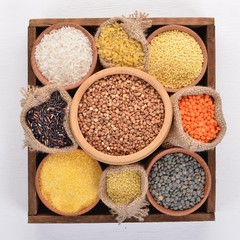 A set of cereals and grains in a wooden basket on a wooden background. Top view. Copy space.