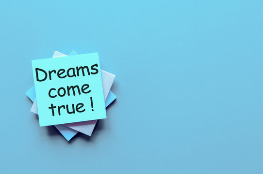Hand writes Dreams come true - on light blue background with empty space for text and mock up