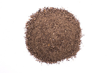 A pile of a  dry black pepper powder isolated on white background