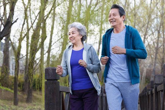 Senior couple jogging out in the park
