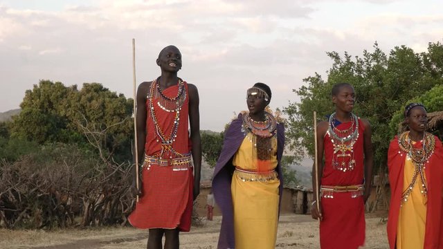 panning shot of a group of maasai women and men singing and dancing at a village near masai mara,kenya