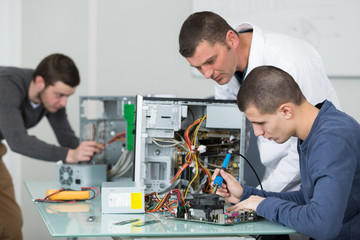 Students learning to solder computer components