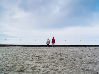 children run on the beach in winter