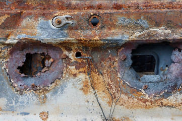 Two through holes in the old rusty car body