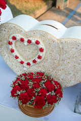 heart shape box with red rose for gift at wedding reception in Thai wedding party. Wedding attributes.  luxury wedding gift box with roses greeting for bride and groom. close up