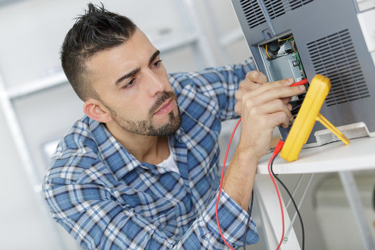 engineer using a voltage and current tester
