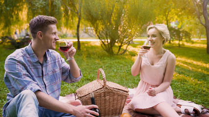 Young soulmates having fun and communicating, enjoying taste of wine open air