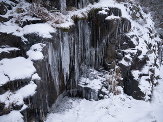Fototapeta na wymiar Frozen ice hanging down from the mountain side