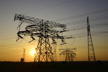 Fototapeta premium High voltage towers under the setting sun, close-up