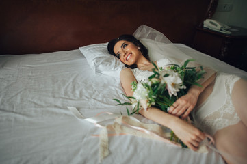 beautiful bride with a bouquet of flowers in the hotel room