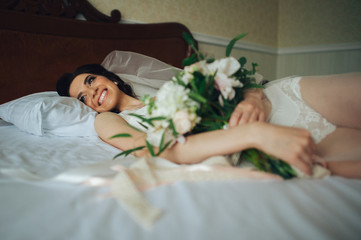 luxury bride in vintage dress with bouquet posing in luxury hote