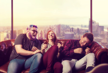 Home party, friends sitting on the couch and laugh