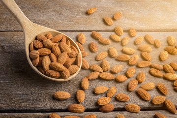 Almonds pour from wood spoon