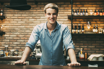 Happy Handsome Blond Bartender Standing at Counter