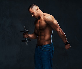 Obraz na płótnie Canvas Athletic shirtless male biceps dumbbell workout.