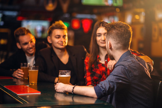 Fun friends drinks beer at the bar counter