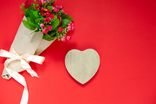 Valentine's day gift for the second half, a bouquet of flowers, a romantic photo, a wooden heart on a red background, background suitable for advertisement , insert text