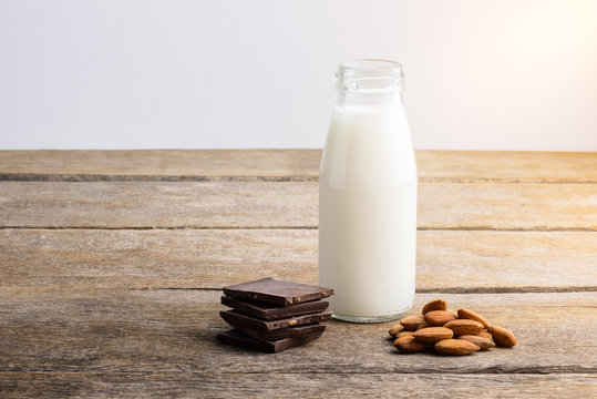 milk in bottle, chocolate and almond on wooden