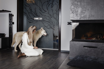 Elegant woman near the fireplace with a dog