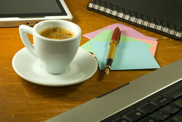  cup of coffee, stationery, keyboard and tablet on the table closeup