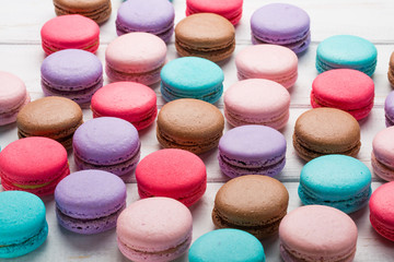 Fototapeta na wymiar Close up colorful macarons dessert on a wooden table. Sweet french macaroons background.
