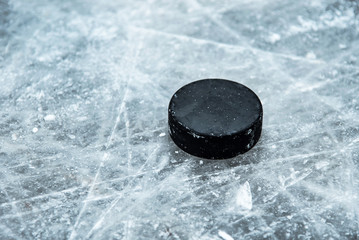 hockey puck lies on the snow close-up - obrazy, fototapety, plakaty