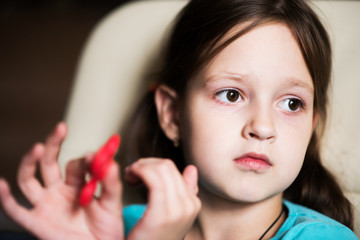 girl to play with the spinner sitting on a chair