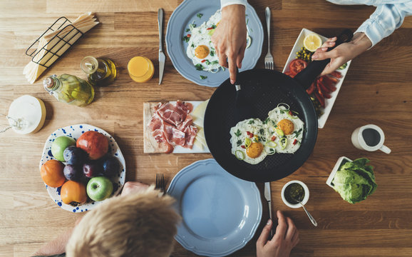 Hipster girl prepared fried eggs for the monday breakfast, top view of happy couple having morning breakfast meal together, togetherness and enjoyment concept