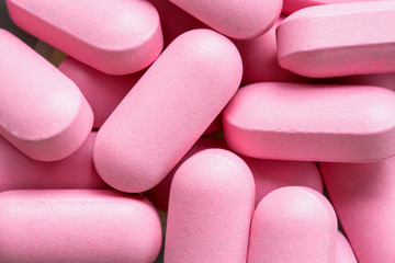Obraz na płótnie Canvas Pink pills background, close up
