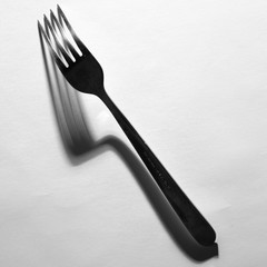 Fork isolated with creative shadow, black and white