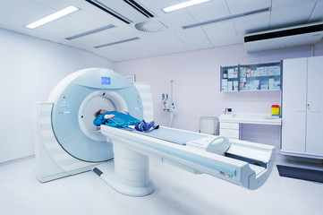 Female patient undergoing CT - Computerized Tomography Scan in Hospital. Patient wearing lead apron to   cover vital organs.