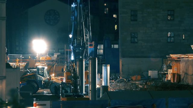 Construction site at night with a lot of construction equipment