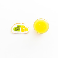 Tasty sandwich with fruits and fresh citrus juice on white background. Flat lay, top view