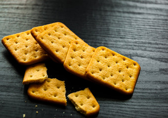 Square dry salted crackers on dark wooden background