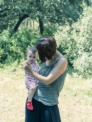 Portrait of happy mother with her baby girl in a countryside