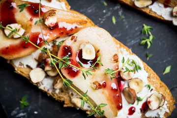 Bread with ricotta cheese and pears on the wooden background. Shallow depth of field.