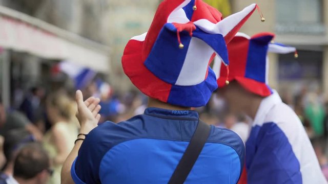 Fans of French soccer team clapping hands and whistling supporting favourites