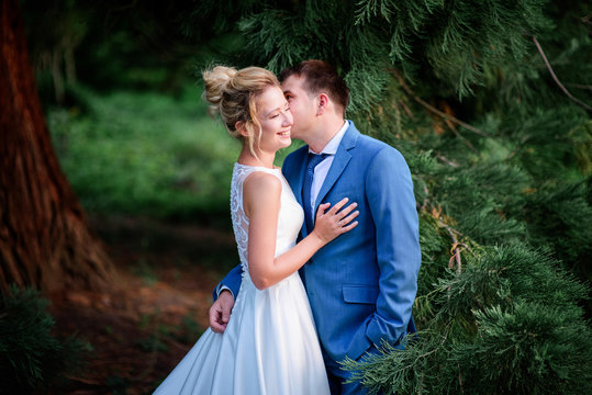 Bride and groom look gorgeous walking in a green summer park