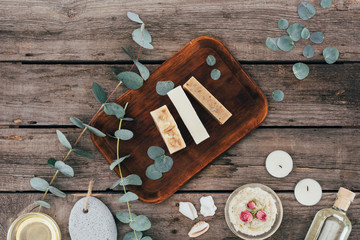 top view of homemade natural soap, eucalyptus and spa treatment on wooden board