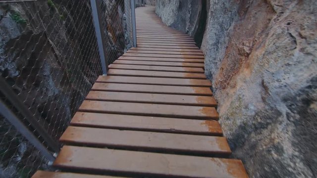 Slow motion POV of man walk on most dangerous but beautiful and scenic, epic hanging bridge on mountain cliffs, hang over abyss. Mesmerizing and beautiful inspiring travel exploration place