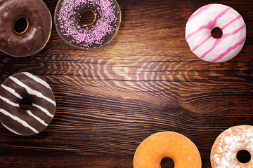 Fototapeta na wymiar Assorted donuts on wooden background