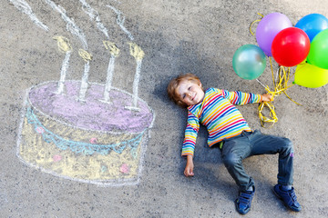 Fototapeta premium Kid boy having fun with colorful birthday cake drawing with chal