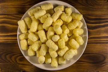 Sweet corn sticks on a plate on wooden table