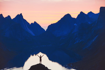 people and nature, silhouette of person with raised hands on beautiful mountain landscape at sunset