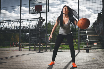 Obraz premium Female basketball player training outdoors on a local court