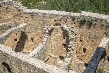 Ruined remains of the interior of an ancient medieval castle, part of the half barrel vault roof,...