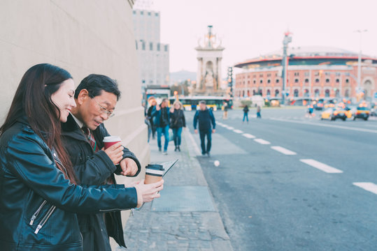  Japanese grandfather and granddaughter tourist using a map in Plaza de Espa&ntilde;a BArcelona with views to Arena bullring