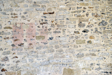 Multicolored ancien exposed stone wall background.