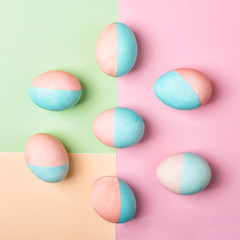 Colorful Easter eggs background. Chicken eggs colored half pink, half blue. Top view, flat lay