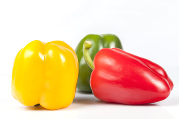 Green red and yellow peppers isolated